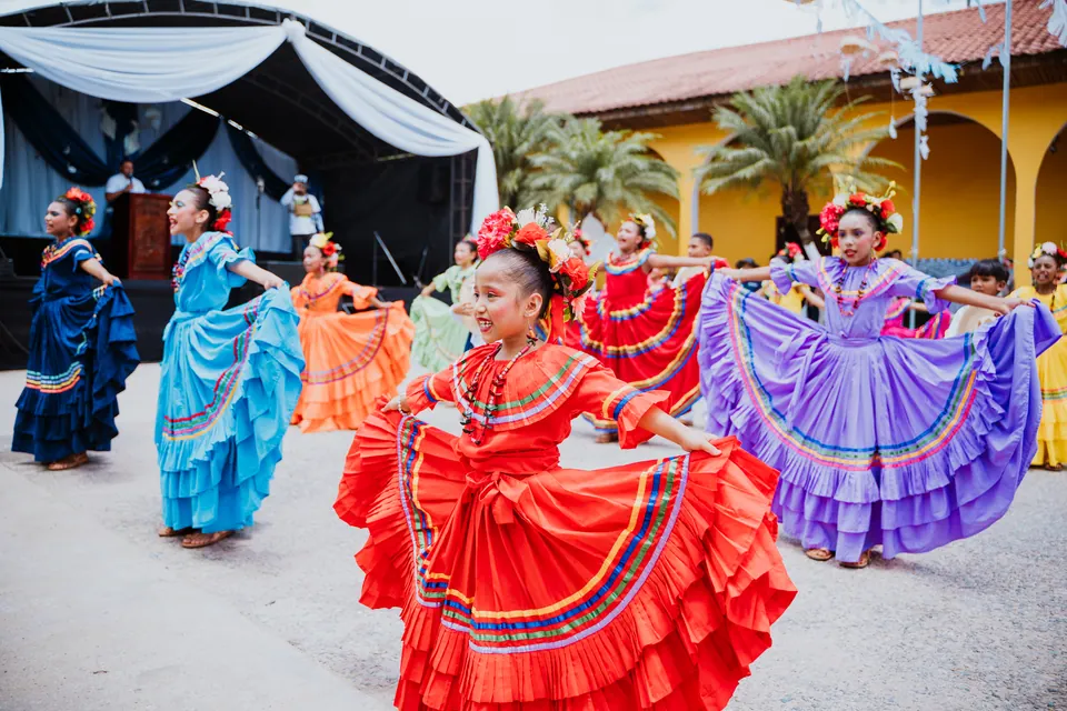 Grupo de danza infantil en una presentación frente a un escenario
